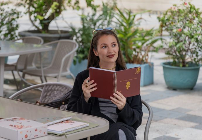 Woman reading a book outdoors in a garden setting