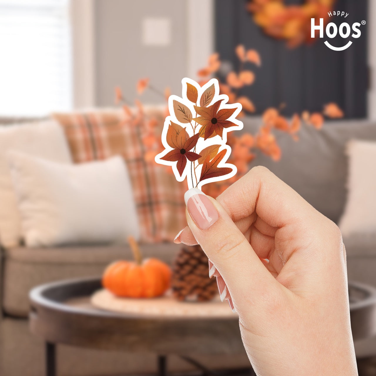 hand holding Autumn Florals sticker featuring burnt orange and rust-colored flowers with star-shaped petals and matching autumn leaves arranged in a vertical floral spray, measuring 2.5 by 3.8 inches