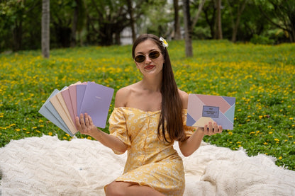 Woman holding Happy Hoos summer notebooks and box outdoors
