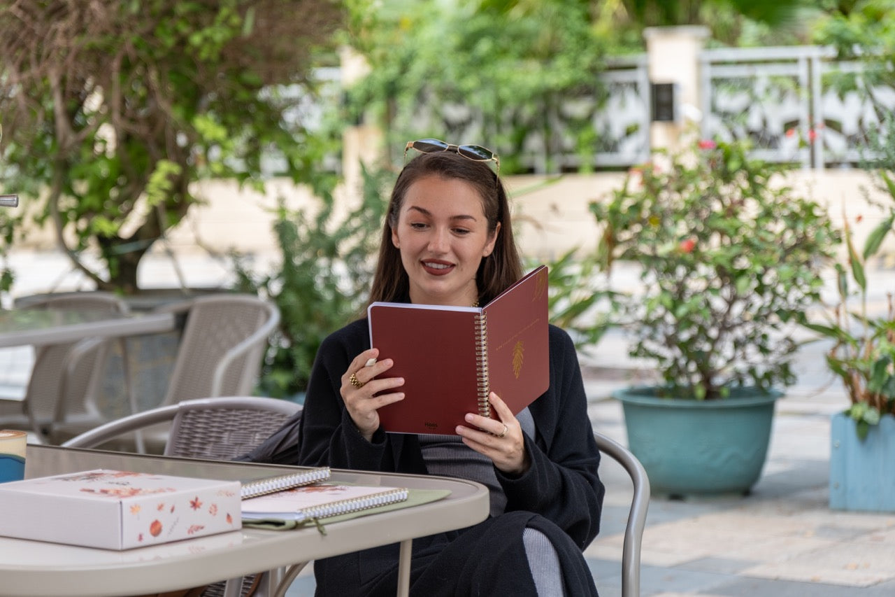 Woman reading a book outdoors in a garden setting