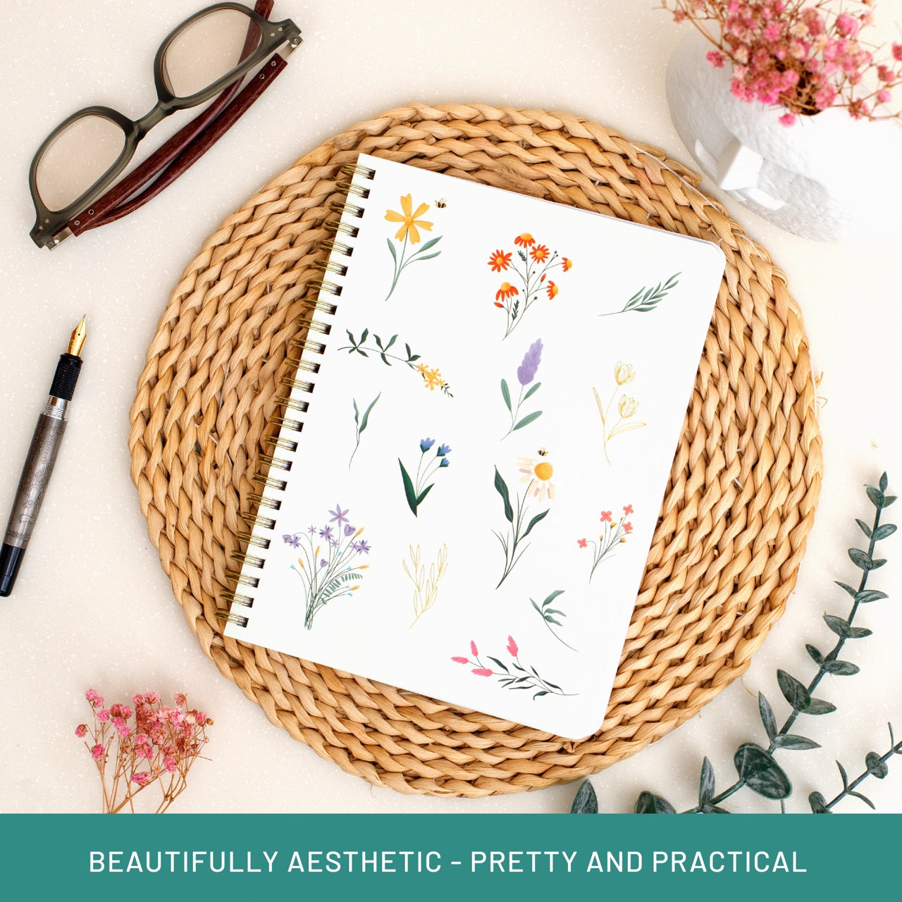 Notebook with floral design on a woven mat with glasses and pen, text 'BEAUTIFULLY AESTHETIC - PRETTY AND PRACTICAL'.