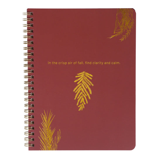 Red notebook with gold leaf designs and text on a white background