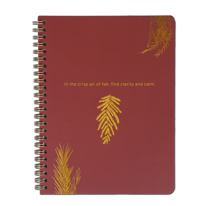 Red notebook with gold leaf designs and text on a white background
