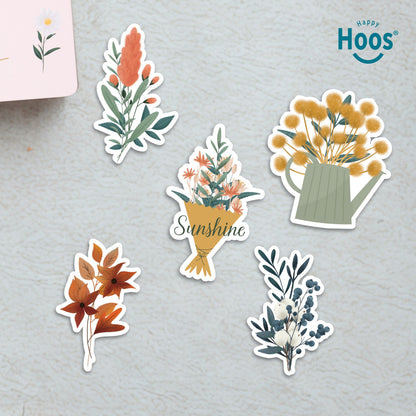 Six Botanical Florals stickers on surface: coral botanical stem, flower bouquet with "Sunshine", yellow flowers in watering can, orange autumn leaves, winter botanical with berries