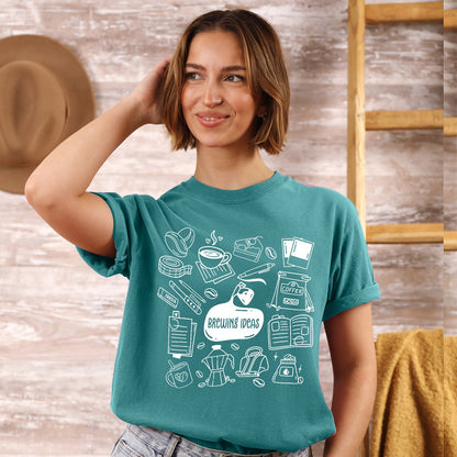 Woman wearing a teal t-shirt with white coffee-themed graphics against a wooden background.