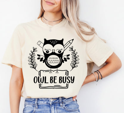 Person wearing a beige t-shirt with an owl graphic and 'OWL BE BUSY' text.