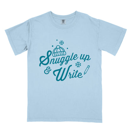 light blue t-shirt with 'Snuggle up & Write' text, holding a coffee cup.
