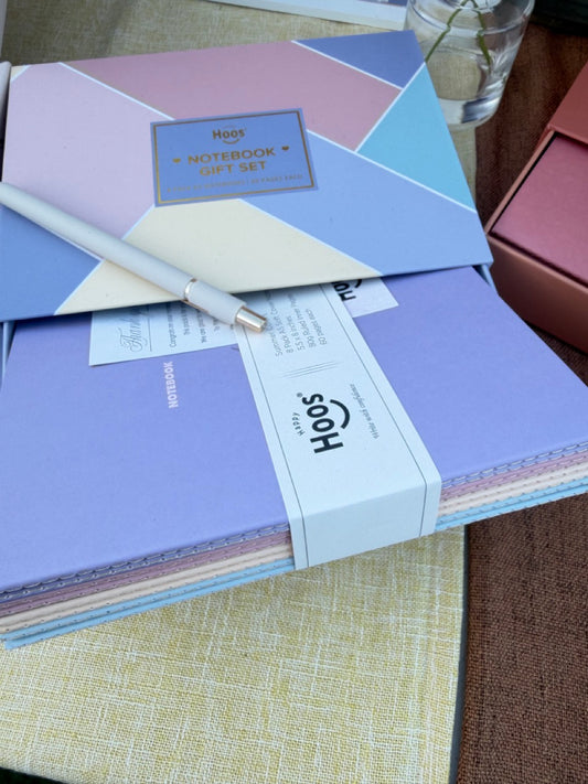 Set of notebooks with a pen on a textured surface