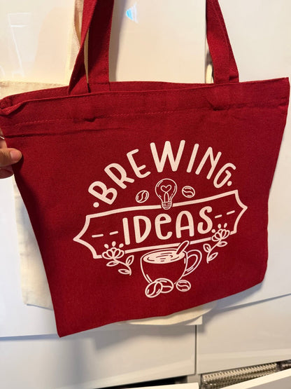 Red tote bag with 'Brewing Ideas' text and graphics on a white background