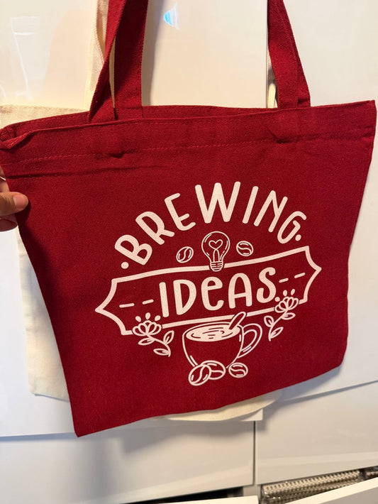 Red tote bag with 'Brewing Ideas' text and graphics on a white background