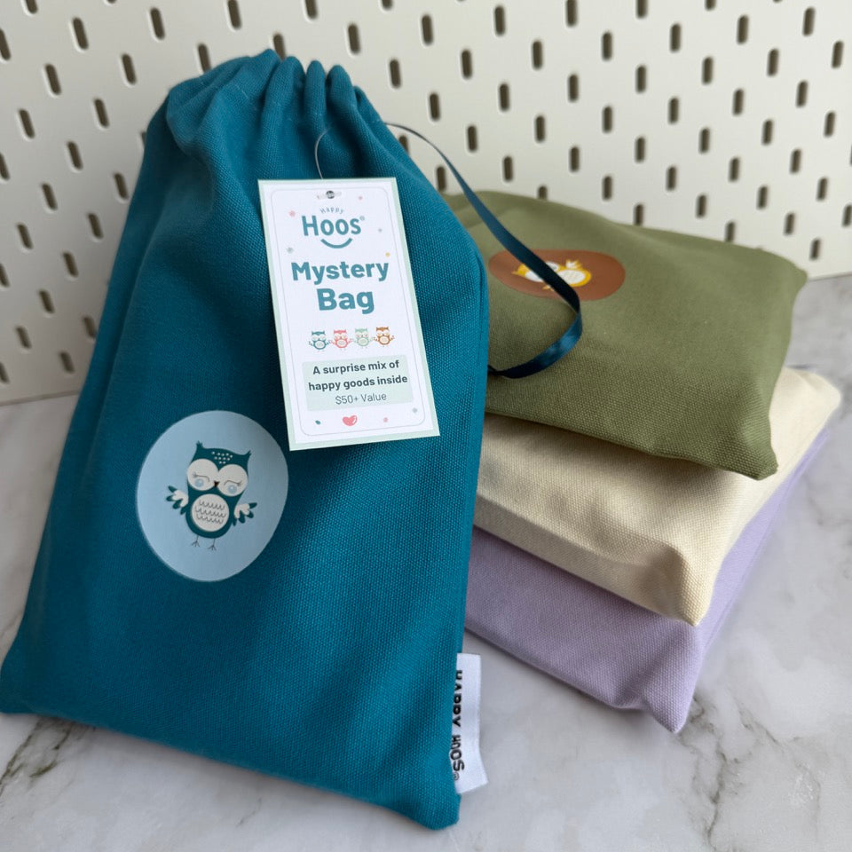 Teal drawstring bag with a label of mystery bag on a marble surface
