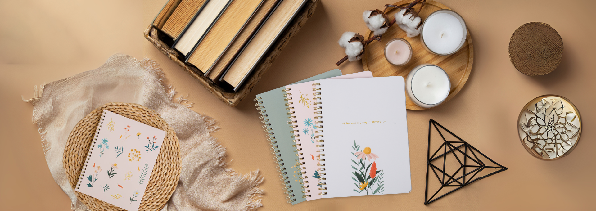 Notebooks, candles, and decorative items on a beige surface