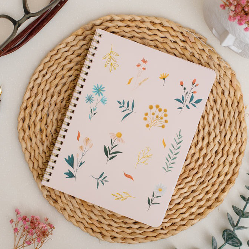 Summer Garden notebook with floral pattern on a woven mat