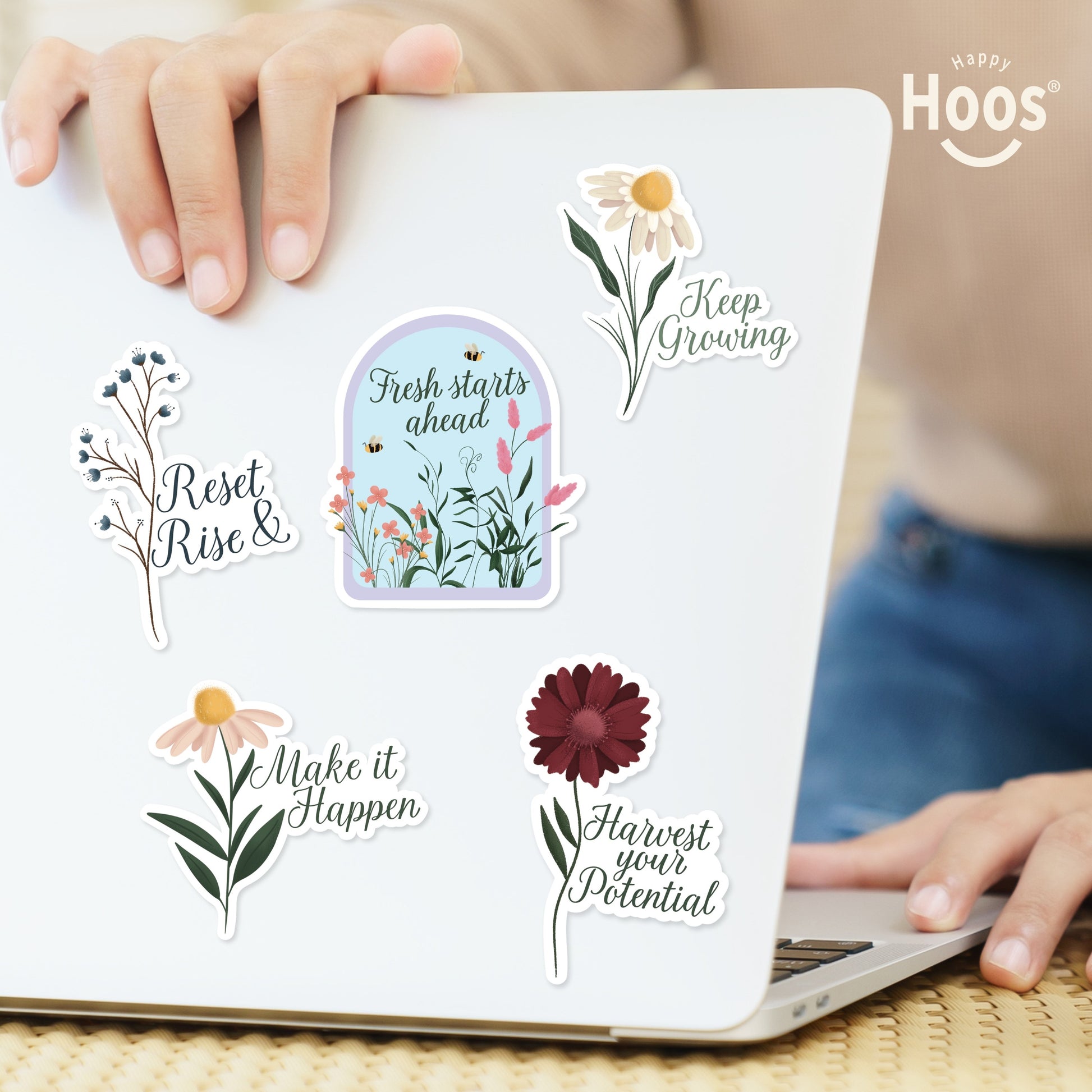 Laptop decorated with Growth & Goal stickers: blue berry branches with "Reset & Rise", garden dome with "Fresh starts ahead", white daisy with "Keep Growing", daisy with "Make it Happen", burgundy flower with "Harvest your Potential"