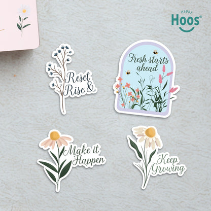 Set of motivational stickers with floral designs and text on a gray surface, featuring the brand 'Hoos'.  The following text are presented in each sticker: Reset & Rise, Fresh Starts Ahead, make it Happen, Keep growing. 