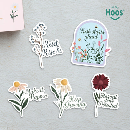 Five Growth & Goal stickers on surface: blue berry branches with "Reset & Rise", garden dome with "Fresh starts ahead", daisy with "Make it Happen", white daisy with "Keep Growing", burgundy flower with "Harvest your Potential"