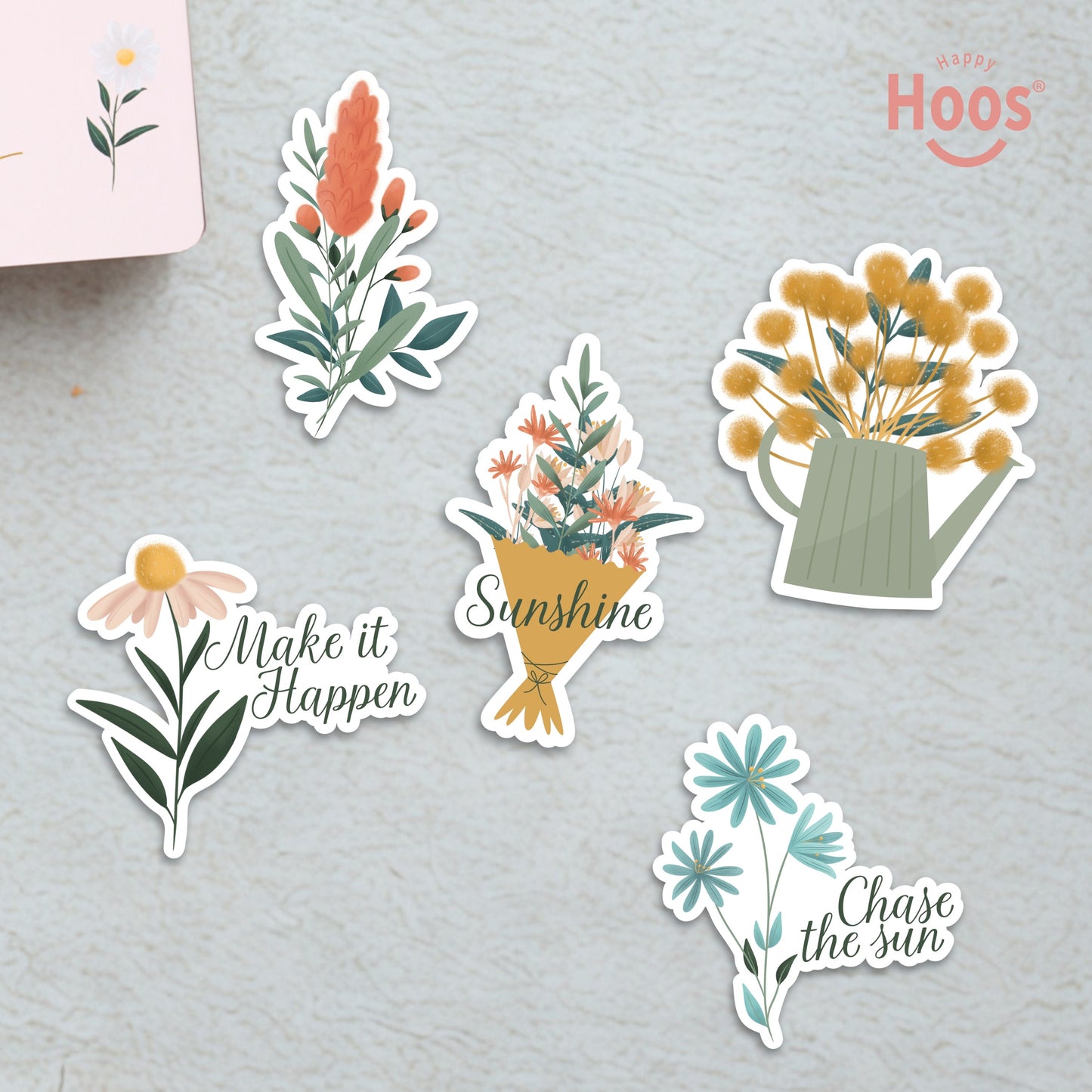 Five summer stickers on surface: coral botanical stem, flower bouquet with "Sunshine", yellow flowers in watering can, daisy with "Make it Happen", blue flowers with "Chase the sun"