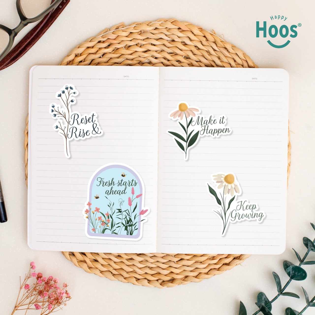 Set of motivational stickers with floral designs and text on a notebook, branded 'Hoos'. The following text are presented in each sticker: Reset & Rise, Fresh Starts Ahead, make it Happen, Keep growing. 