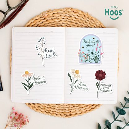 Growth & Goal stickers on open journal: blue berry branches with "Reset & Rise", daisy with "Make it Happen", garden dome with "Fresh starts ahead", white daisy with "Keep Growing", burgundy flower with "Harvest your Potential"