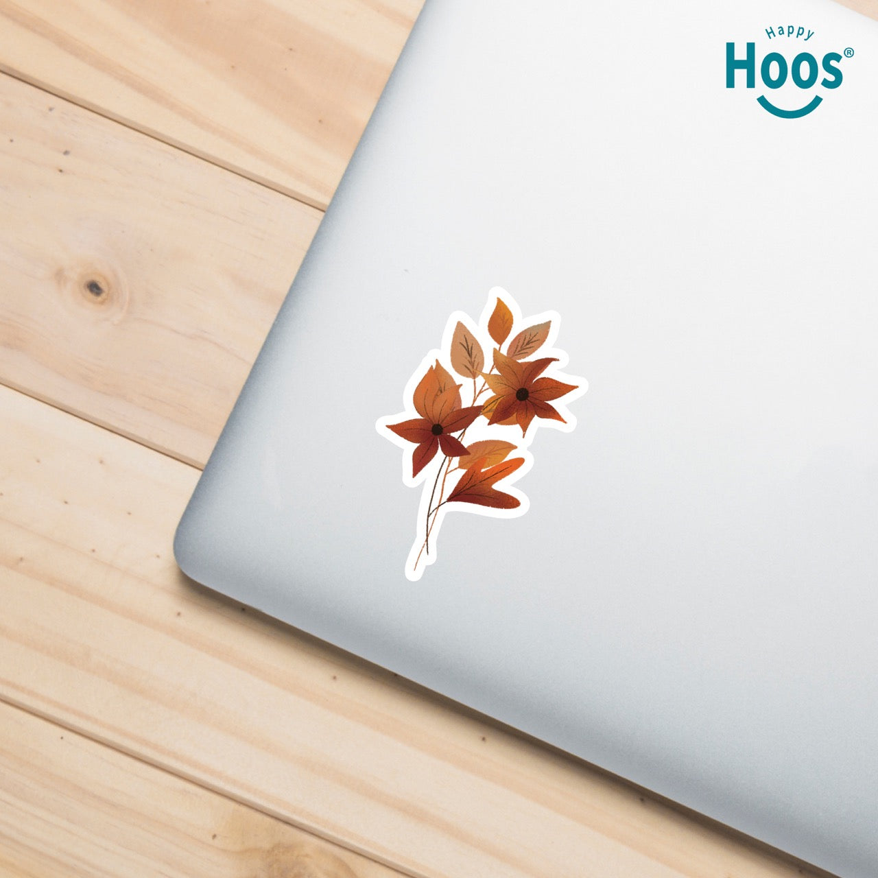 Autumn Florals sticker featuring burnt orange and rust-colored flowers with star-shaped petals and matching autumn leaves arranged in a vertical floral spray, measuring 2.5 by 3.8 inches on laptop