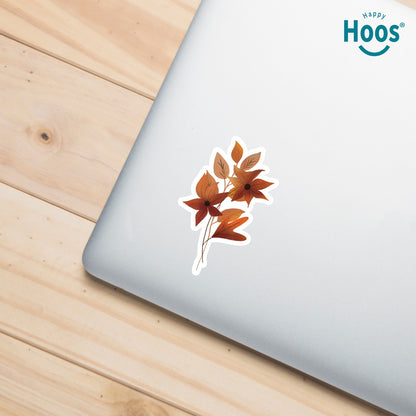 Autumn Florals sticker featuring burnt orange and rust-colored flowers with star-shaped petals and matching autumn leaves arranged in a vertical floral spray, measuring 2.5 by 3.8 inches on laptop