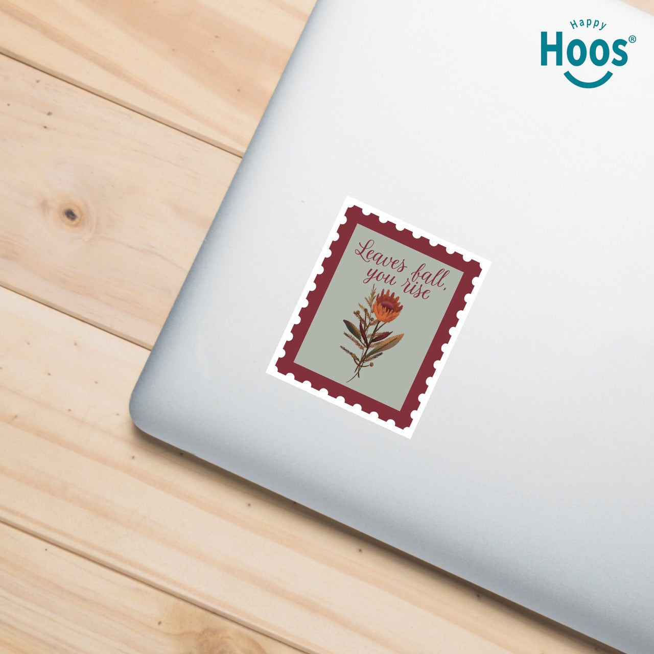 laptop with 
Fall & Rise sticker designed as a vintage postage stamp with burgundy perforated border, sage green background, featuring autumn botanicals with orange flowers and brown foliage, and burgundy script lettering reading "Leaves fall, you rise" at the top, measuring 2.5 by 3.3 inches