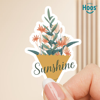 Sticker with floral design and 'Sunshine' text held by a hand, with 'Happy Hoos' logo in the corner.