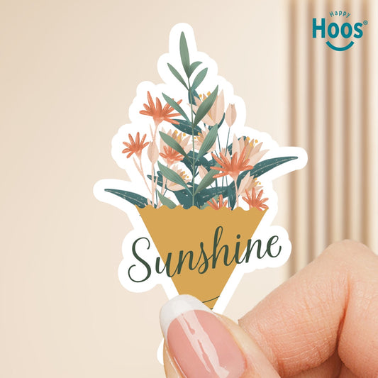Sticker with floral design and 'Sunshine' text held by a hand, with 'Happy Hoos' logo in the corner.