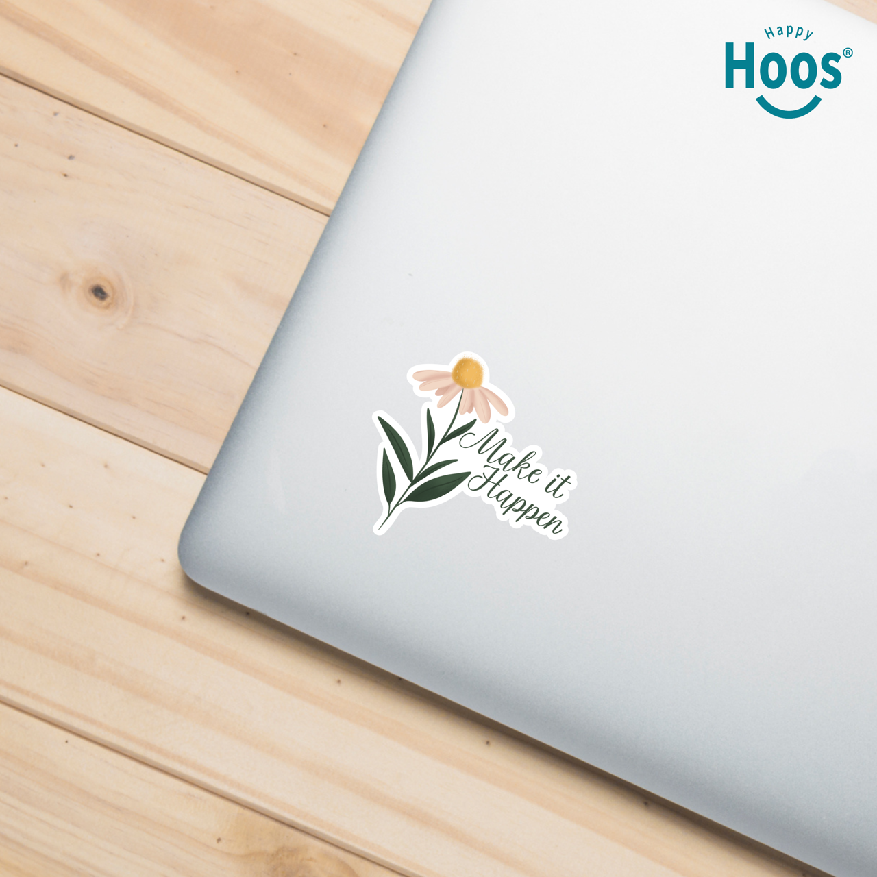 Laptop with a sticker on a wooden surface, featuring the 'Happy Hoos' brand.