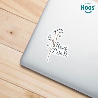 Laptop with a motivational sticker on a wooden surface, featuring the brand 'Happy Hoos'.