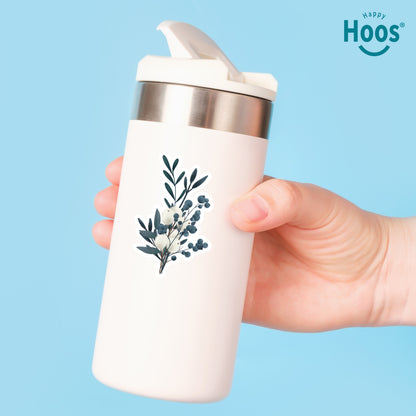 White tumbler with Winter Eucalyptus floral design held by a hand against a blue background, featuring the 'Happy Hoos' brand.