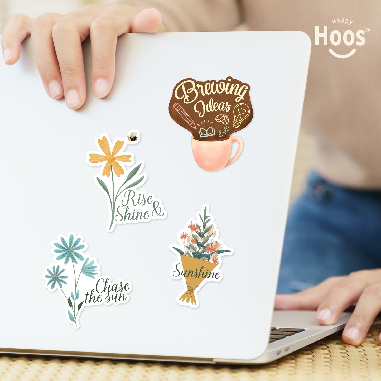 Laptop decorated with Morning Motivation stickers: yellow daisy with bee and "Rise & Shine", coffee mug with "Brewing Ideas", blue flowers with "Chase the sun", flower bouquet with "Sunshine"