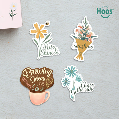 Four Morning Motivation stickers on surface: yellow daisy with bee and "Rise & Shine", flower bouquet with "Sunshine", coffee mug with "Brewing Ideas", blue flowers with "Chase the sun"