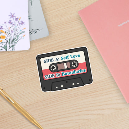 Cassette tape design with 'Self Love' and 'Boundaries' text on a wooden surface.