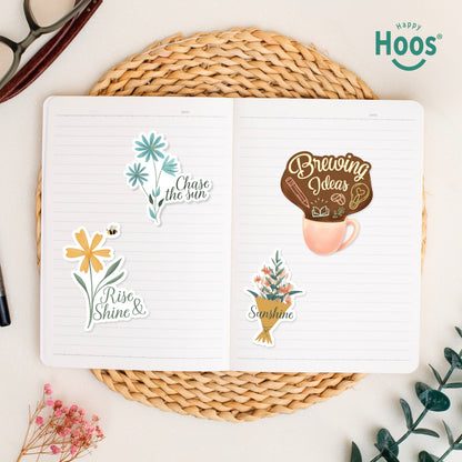 Botanical Florals stickers on open journal: winter botanical with berries, flower bouquet with "Sunshine", yellow flowers in watering can, coral botanical stem, colorful wildflower bouquet, orange autumn leaves
