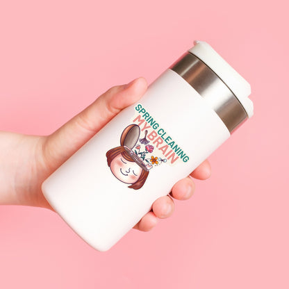 Spring Cleaning My Brain waterproof sticker on a water bottle featuring a smiling face with flowers growing from an open head, made for self care, overthinkers, mental reset, planners, laptops, and water bottles.